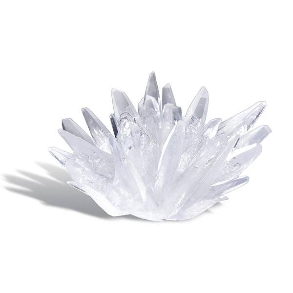 A cluster of clear quartz crystals with elongated, transparent points fanning out from a central base, casting a soft shadow on a white background, reminiscent of creations from the 4M Crystal Growing Easy STEM Science Experiment by Toysmith.