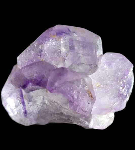 The Crystalary's Fluorite from Huallanca, Peru (SKU 804) features a close-up of translucent crystals against a black background, highlighting natural jagged formations in light purple hues with white inclusions.