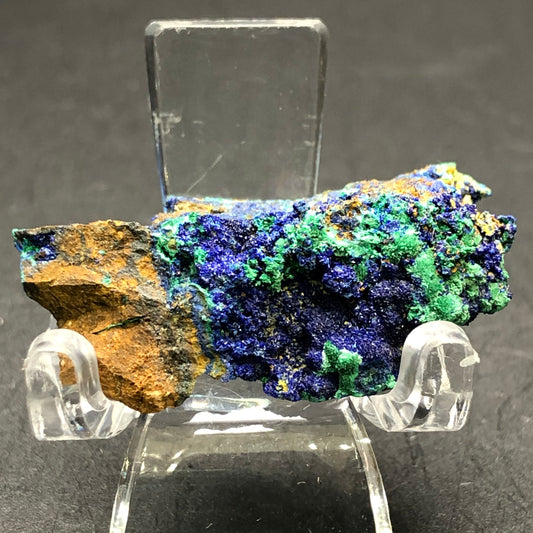 The Crystalary's AUCTION Azurite Malachite from Bisbee, Conchise County, Arizona, showcases deep blue druzy azurite and green malachite on a clear stand. The mineral rock's rough surface adds intriguing textures and patterns.