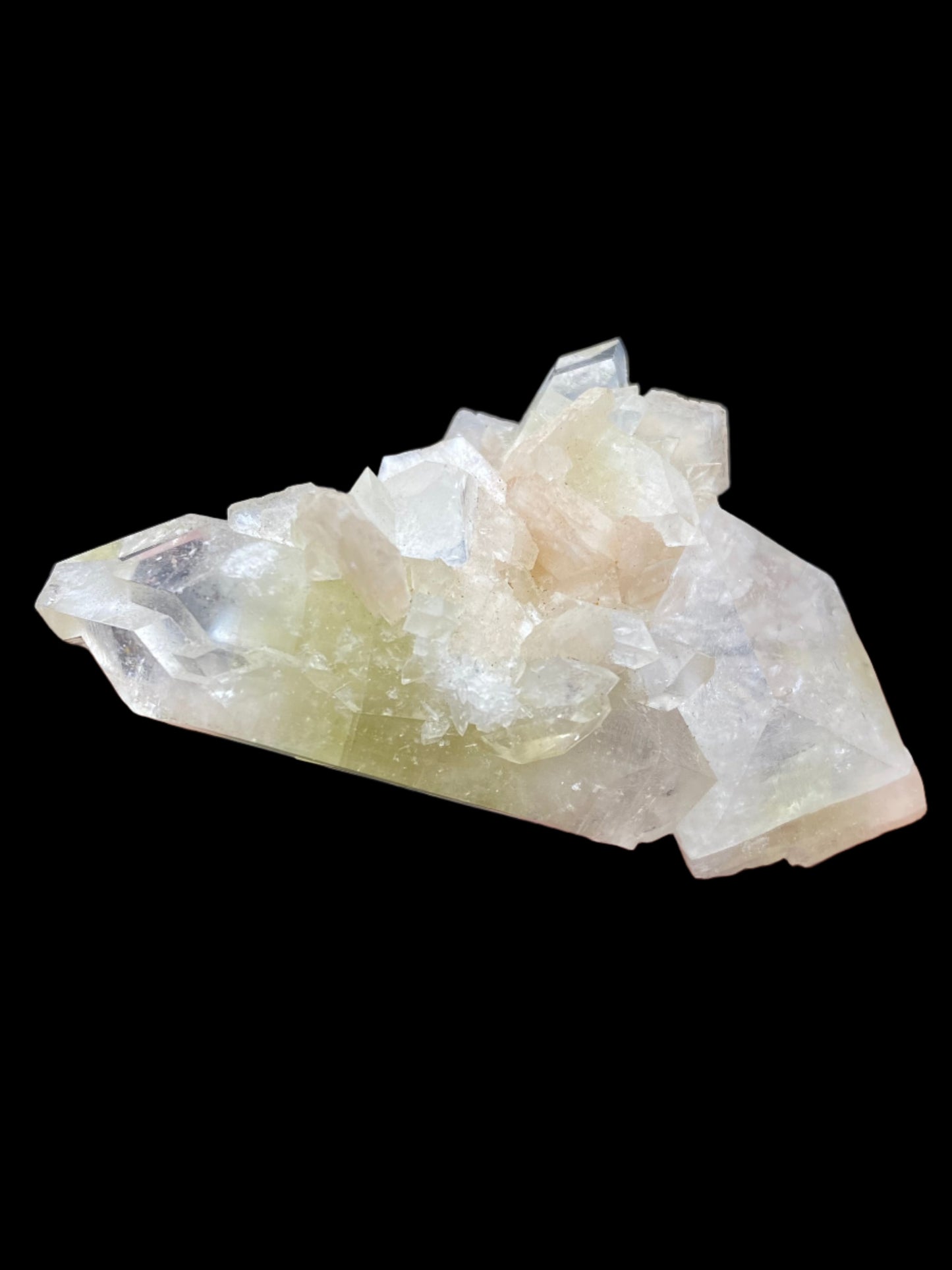 A stunning display of Apophyllite crystals from The Crystalary, sourced from the Lonavala Quarry in the Pune District of Maharashtra, India. These crystals feature clear quartz formations with subtle inclusions of milky white and pale yellow hues, set against a black background. The sharp edges and various hexagonal shapes are reminiscent of this unique find.