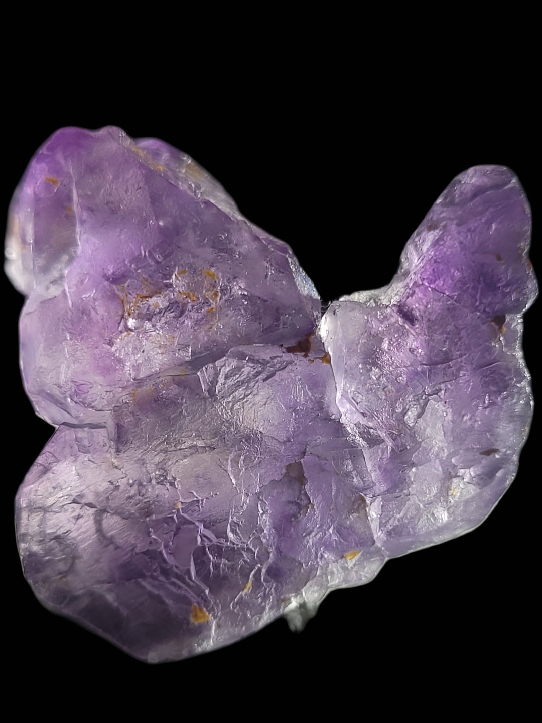 A detailed shot of a rough, purple amethyst crystal shows its texture and natural imperfections against a black background, resembling The Crystalary's rare Fluorite- Huallanca, Ancash, Peru (SKU 803).