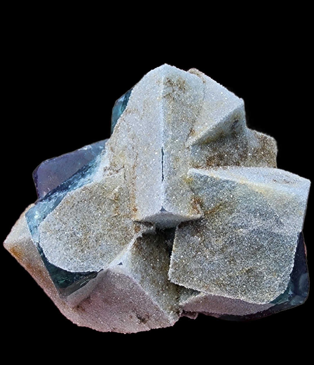 A cluster of light-colored, sand-covered cubic crystals from the Fluorite- Druzy Dreams Pocket at the Rogerley Mine in Frosterley, Weardale, Co. Durham, England sits against a black background. The geometric shapes are distinct, with sharp edges and a sandy texture obscuring some of the crystal clarity. Under UV fluorescence, these crystals from The Crystalary emit a subtle glow, enhancing their natural, earthy appearance.