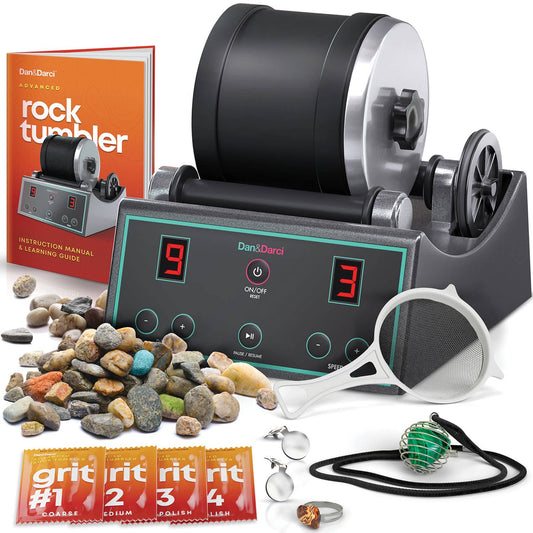 The image showcases the Dan&Darci Advanced Rock Tumbler kit, featuring the tumbler machine, various types of rocks, a manual titled "Dan&Darci Advanced Rock Tumbler," a sifter, four grit packets (coarse, medium, fine, and polish), and accessories like a necklace and magnifying glass for displaying your polished gems.