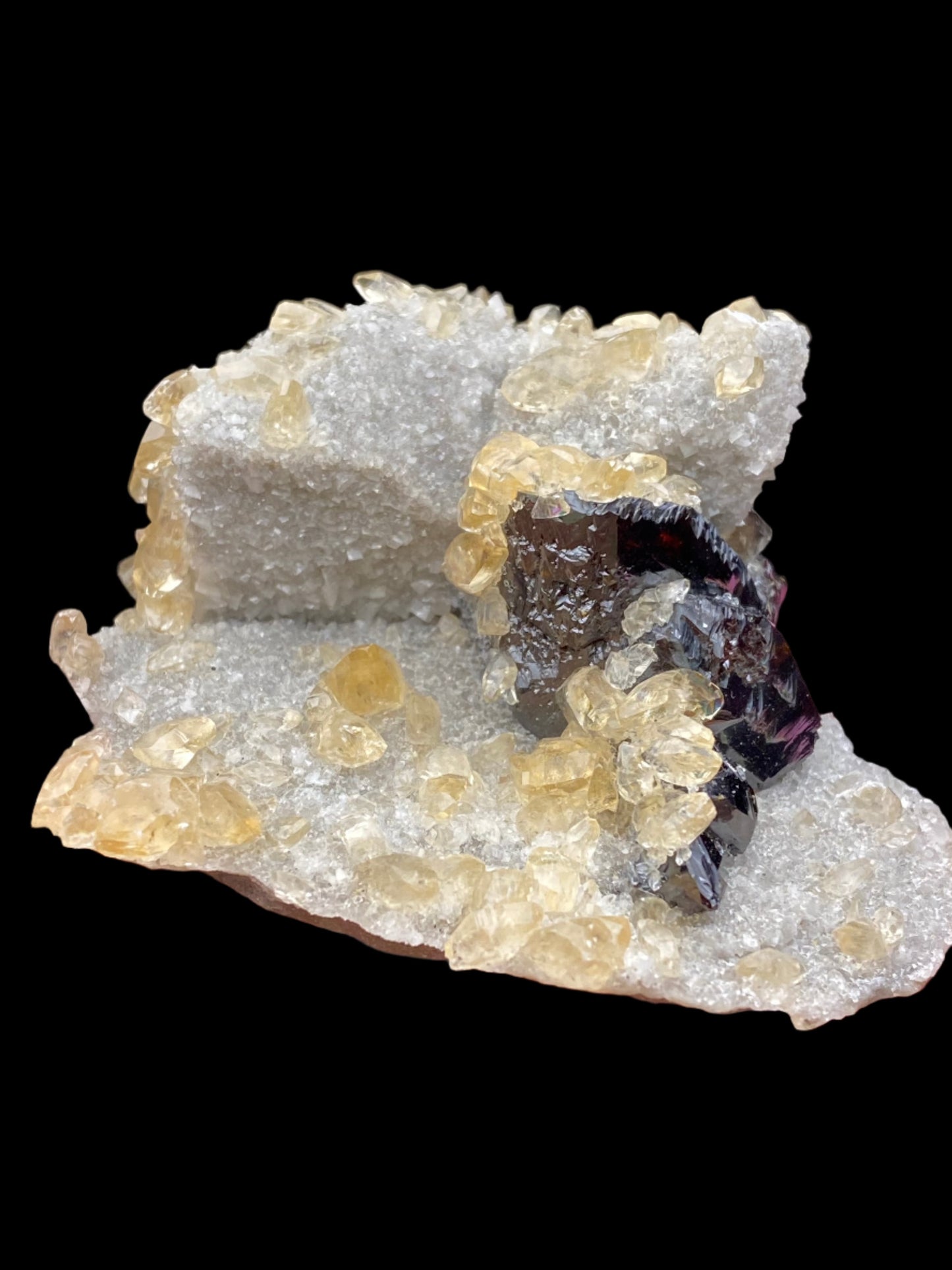 Introducing our stunning Calcite, Quartz, and Sphalerite specimen from the Elmwood Mine in Carthage, Smith County, Tennessee, USA. This mineral masterpiece by The Crystalary features clear, crystal-like formations adorned with scattered golden yellow crystals and small calcites. The piece boasts a rough texture with an intricate and uneven structure, beautifully showcased against a black background.