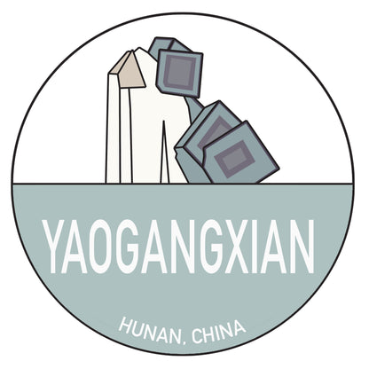 The Chinese Passport Stickers by The Crystalary showcase a circular logo that prominently features stylized mineral representations and the text "YAOGANGXIAN" in bold white letters against a light blue background, giving it the appearance of a vibrant full-color sticker. Below the text, "Hunan, China" is displayed to indicate the location. The upper half of the logo depicts geometric shapes resembling fluorite crystals.