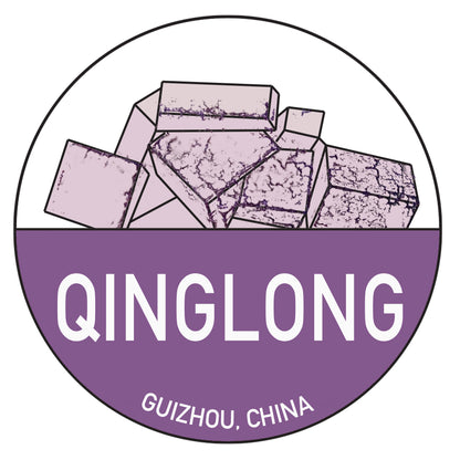 An illustration of several rectangular, purple minerals inside a circular frame, titled "Chinese Passport Stickers." Below the minerals, the text reads "QINGLONG," and further down, "GUIZHOU, CHINA" in smaller font. Both texts are in white on a solid purple background. This design beautifully captures the style of Fluorite Passport stickers from The Crystalary.