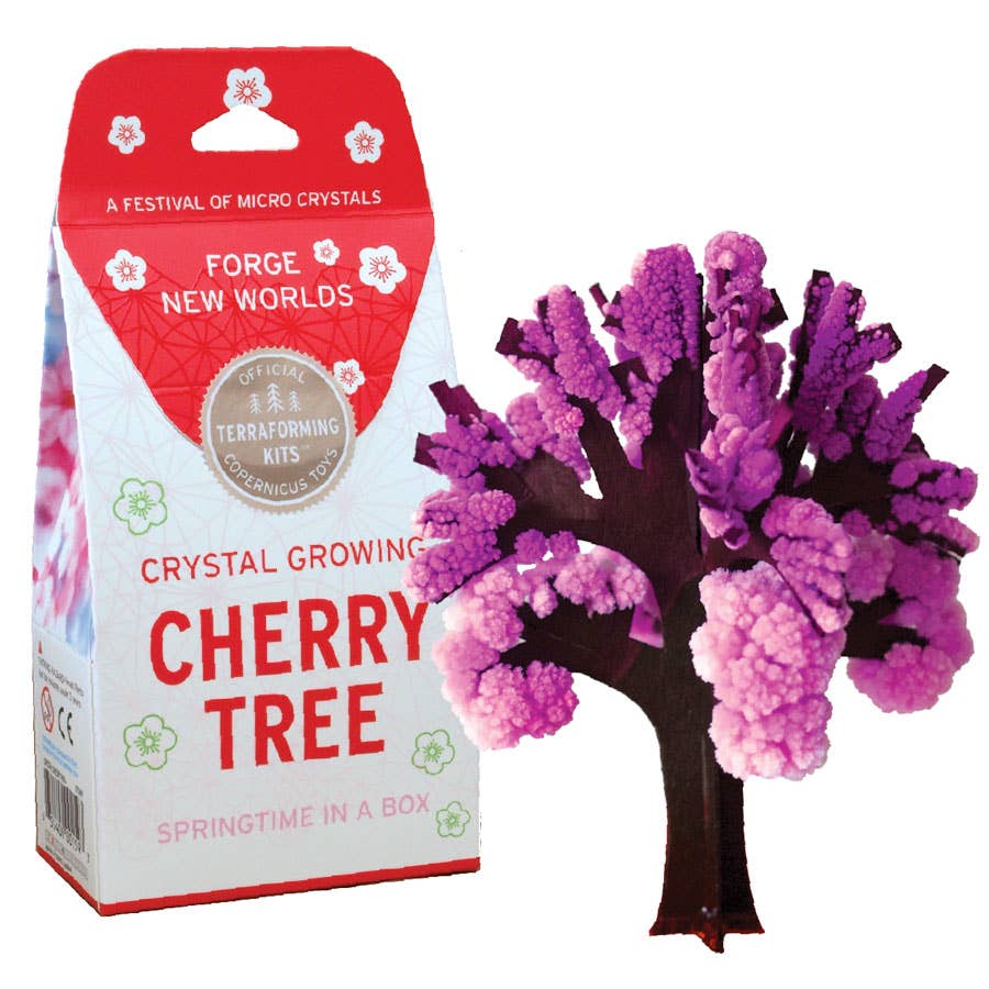 A DIY kit package labeled "Crystal Growing Cherry Tree" with an image of a vibrant pink and purple crystal tree. Designed by Copernicus Toys for creating a crystallized replica of a cherry tree, it offers the perfect science gift. The box reads "Forge New Worlds" and "Springtime in a Box.