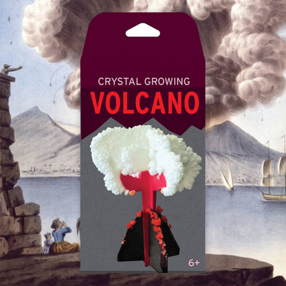 A package labeled "Crystal Growing Volcano | Craft Kit Science Kit" from Copernicus Toys displays a toy volcano with white crystals forming on its eruption. The background features a painting of an erupting volcano and people observing from a distance. This exciting science kit is suitable for ages 6 and up, making it one of the top gifts for young explorers.