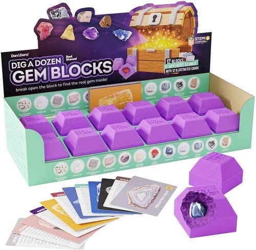 A display box labeled "Dig a Dozen Gem Blocks" by Dan&Darci showcases 12 purple, gem-shaped blocks. One block is broken open to reveal a unique real gem inside. Various gem learning cards are spread out in front, and an illuminated treasure chest adorns the upper right corner of the box.