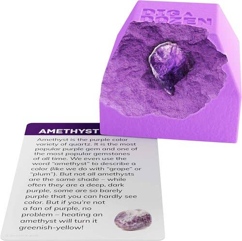 A purple amethyst specimen sits partially embedded in a block from the Dig a Dozen Gem Blocks by Dan&Darci, accompanied by a gem learning card. The card details amethyst's properties, color variations, popularity, and how heating can alter its color to greenish-yellow—perfect for those eager to excavate and uncover unique real gems.