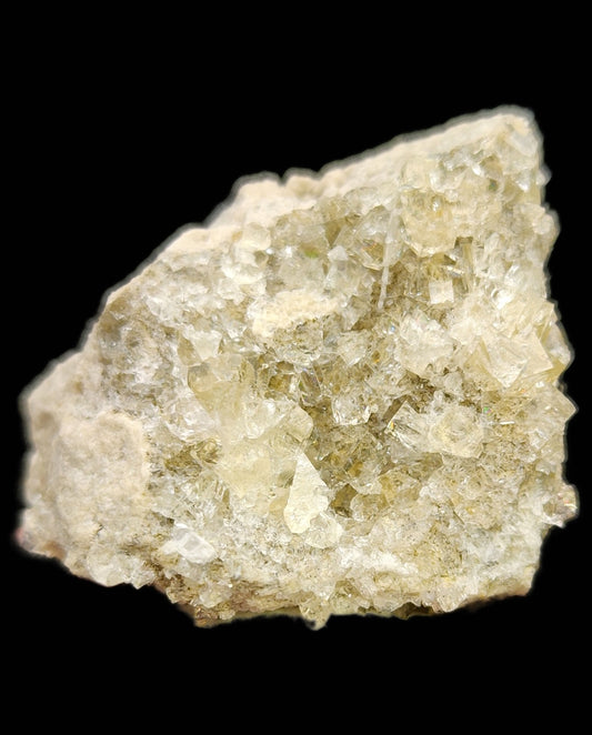 Close-up view of a rough, translucent Fluorite specimen from The Crystalary, featuring a light yellowish hue. This exceptional sample from Celestite- Clay Center, Township of Allen, Ottawa County, Ohio, United States showcases crystalline formations resembling fluorite cubes and is displayed against a black background to highlight its clarity.