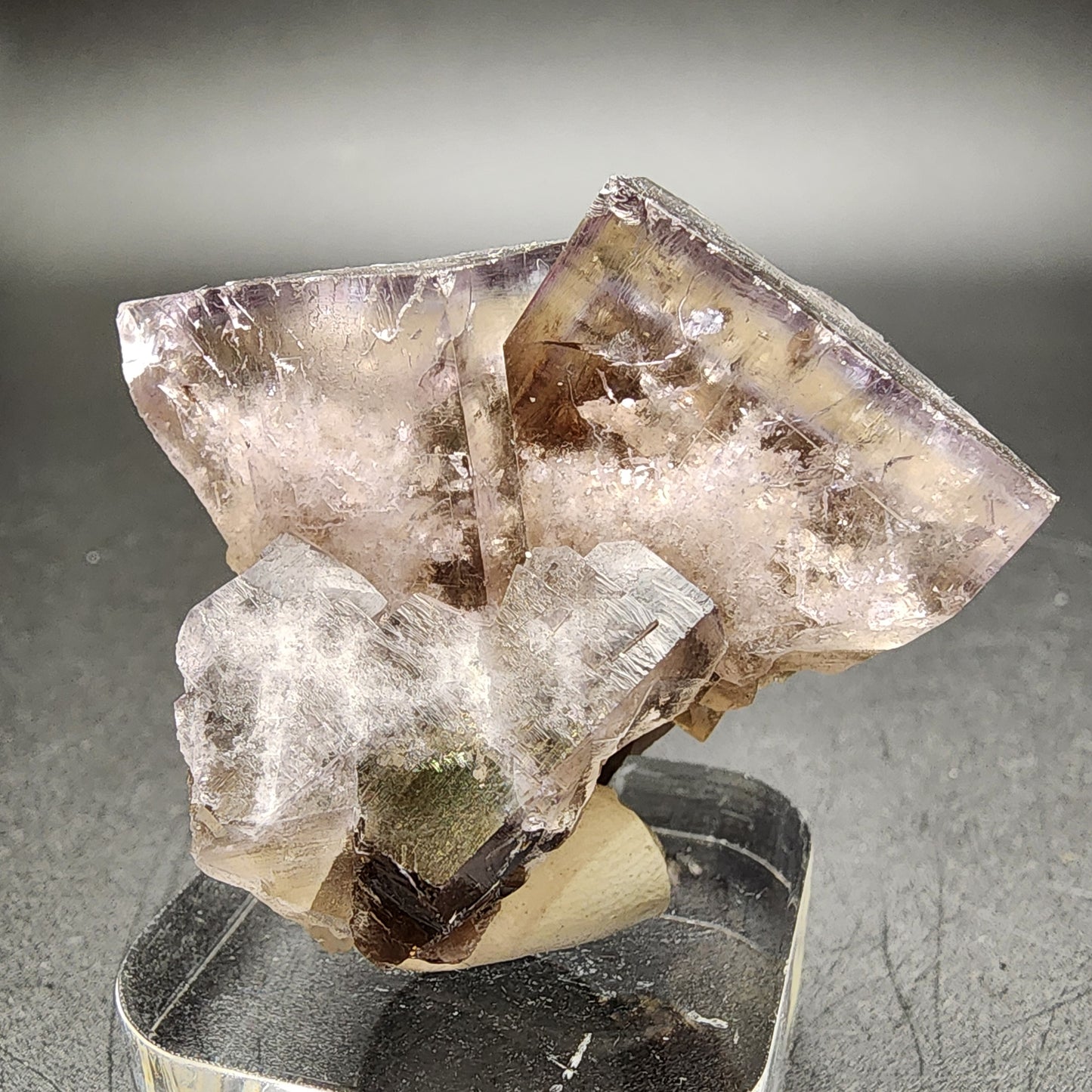 Here's a revised sentence using the given product data:

A close-up of the Fluorite from Cromwell Pocket, Greenlaws Mine, crafted by The Crystalary, reveals a cluster of translucent crystals with a subtle purple tint and well-defined geometric shapes on a dark background. These crystals from Stanhope, Co. Durham exhibit an intriguing daylight color change and intricate structure highlighted by their subtle sheen.