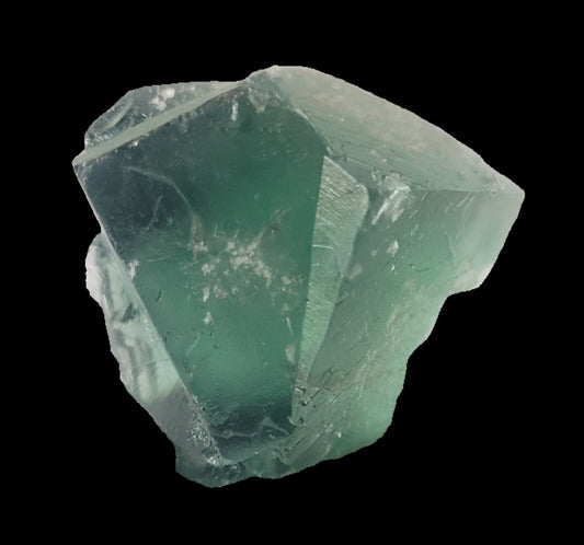 A close-up image of The Crystalary's Fluorite - Excavator Terminator from Lady Annabella, Co. Durham, England mini specimen, featuring a translucent, glassy green crystal. Weighing 19 grams, this stunning piece showcases sharp edges and smooth surfaces that reflect light to reveal its intricate internal structures and depth against a plain white background.