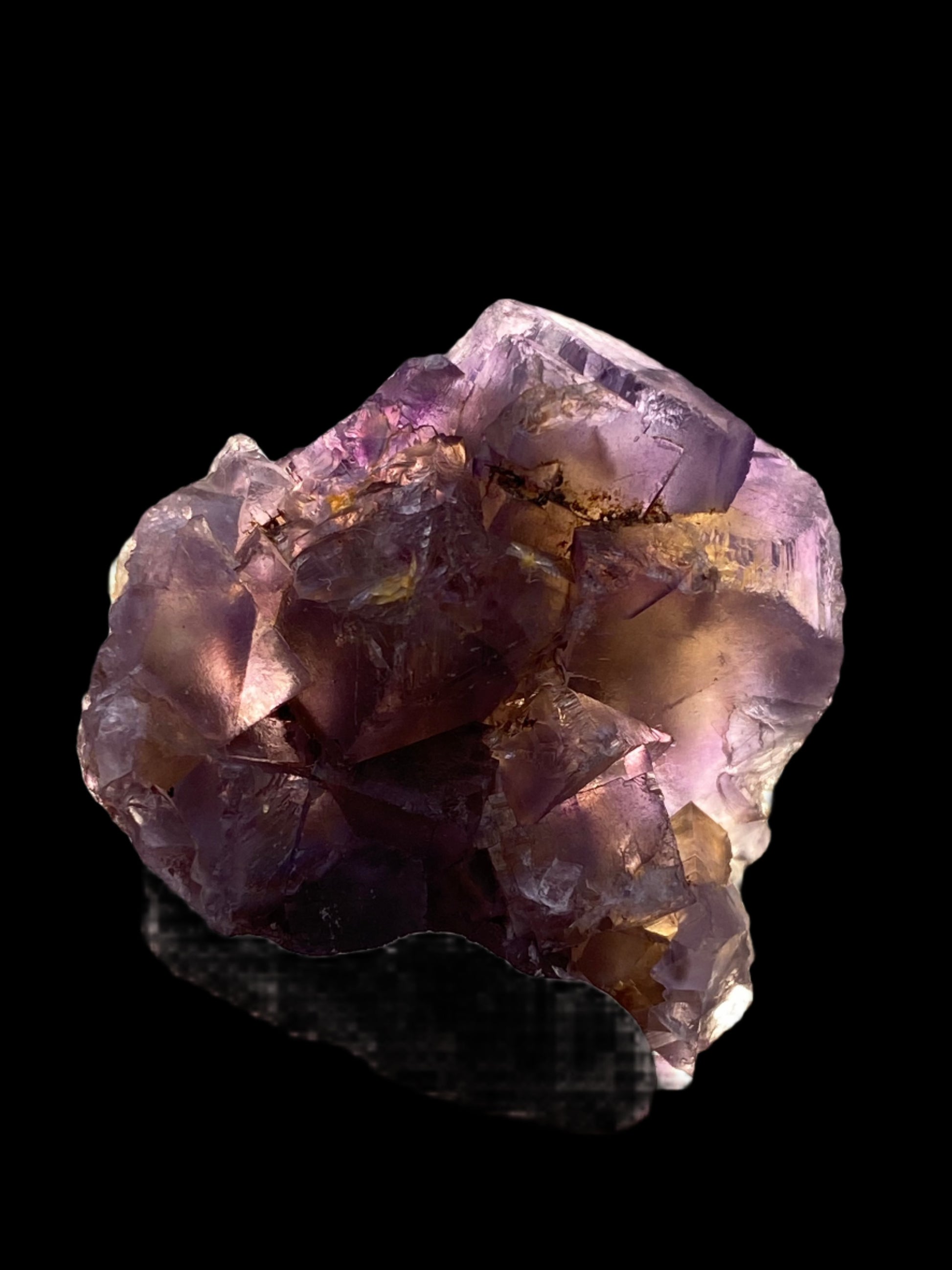 A close-up of a Fluorite crystal from Minerva Mine #1 in Hardin County, Illinois, by The Crystalary, showcasing its purple hues and light violet partial cubes against a black background. The crystal's surfaces display a mix of translucent and opaque textures, highlighting its natural beauty and intricate details.