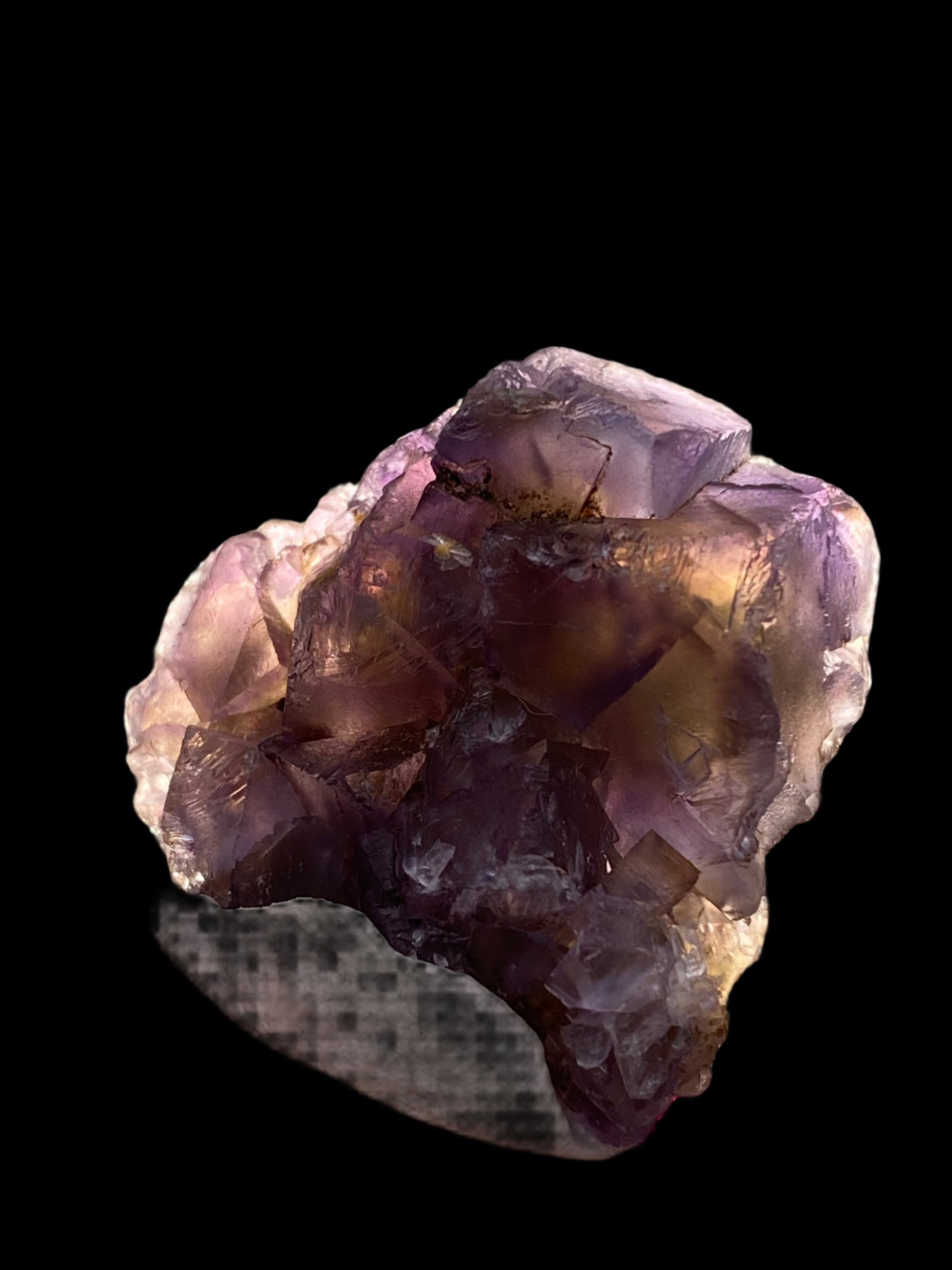 A gorgeous Fluorite specimen from The Crystalary, sourced from Hardin County's Minerva Mine #1 in Illinois, displayed against a black background. The crystal showcases multiple facets with a gradient of rich purple hues blending into lighter shades, along with some light violet partial cubes that appear nearly clear.