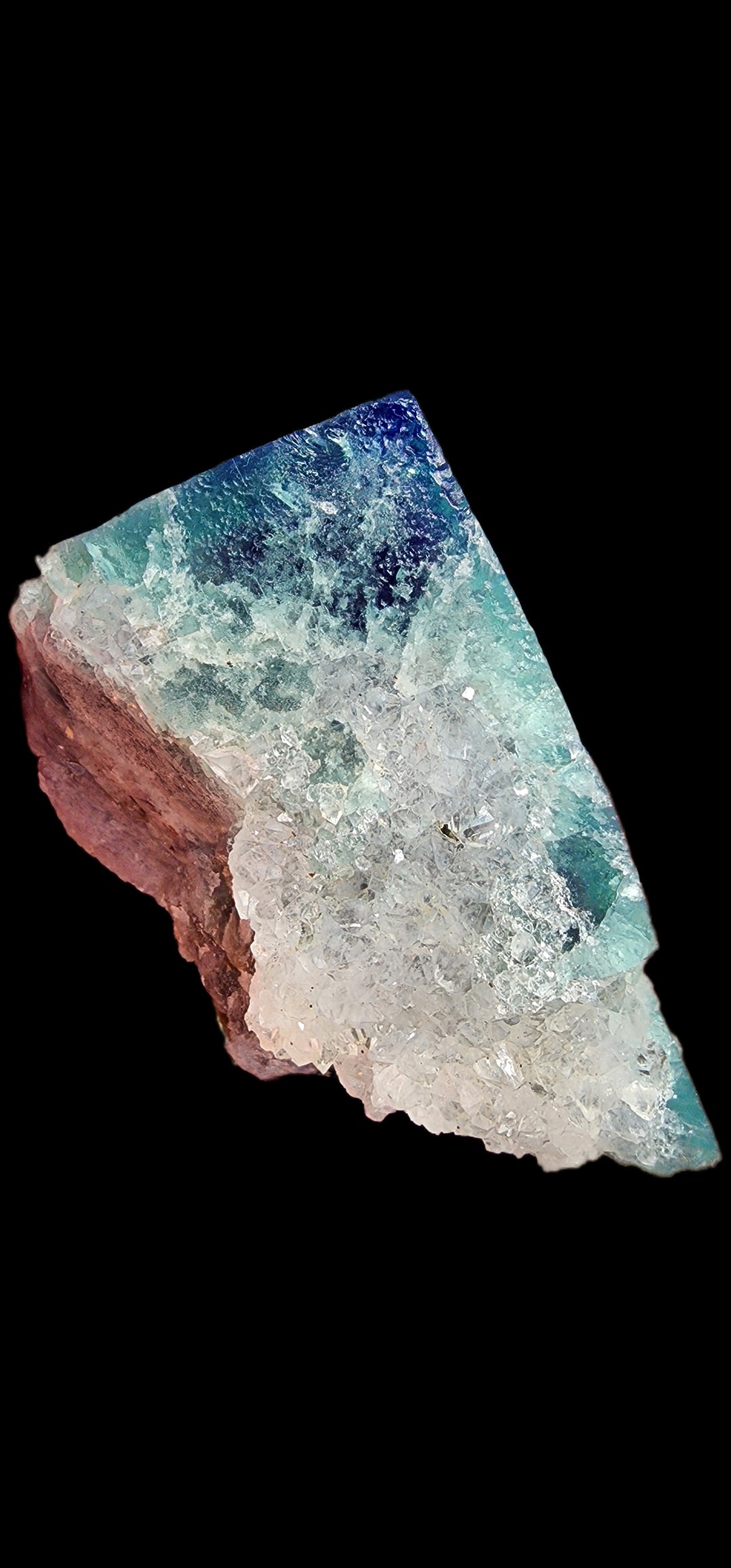 A striking fluorite rock from the Supernova Pocket of the Diana Marie Mine in Weardale, Co. Durham, England, featuring a mix of deep blue, teal, and earthy brown hues. Resembling exquisite quartz crystals, this piece from The Crystalary is set against a solid black background to accentuate its intricate and translucent textures.