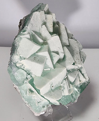 A large, 248-gram seafoam green fluorite specimen, branded as "Fluorite-Yaogangxian with Micro 'Sugar' Quartz" by The Crystalary, features prominent and intricate crystal formations. The crystals have an angular, geometric appearance that lends a jagged texture to the piece. A plain white background accentuates the unique structure of this sugary micro quartz-adorned mineral.