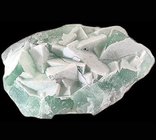 Introducing the Fluorite-Yaogangxian with Micro "Sugar" Quartz by The Crystalary. This stunning specimen features angular, jagged formations of roughly textured light green and white minerals set against a black background. The translucent quality of the fluorite reveals various shades of lucid seafoam green, making it a visually captivating piece.