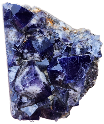 A substantial and rough Weardale cluster of deep purple cubic fluorite crystals sourced from the Yum Yum Pocket at the Diana Maria Mine is embedded in a rocky matrix. The crystals showcase smooth, reflective surfaces and vary in size, with the largest ones prominently jutting out. The rock matrix is lighter in color, accented with hints of orange and white. This exquisite piece is offered by The Crystalary under the name Fluorite - Yum Yum Pocket, Diana Maria Mine, Frosterley, Weardale, England.