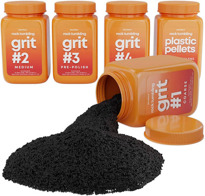 Four orange containers from the "Grit Refill" set by Dan&Darci, labeled "grit #2 medium," "grit #3 pre-polish," "grit #4 polish," and "plastic pellets" are lined up, ready to create gems. A fifth container labeled "grit #1 coarse" lies tipped over, spilling coarse black grit onto the surface, ideal for rock polishing.