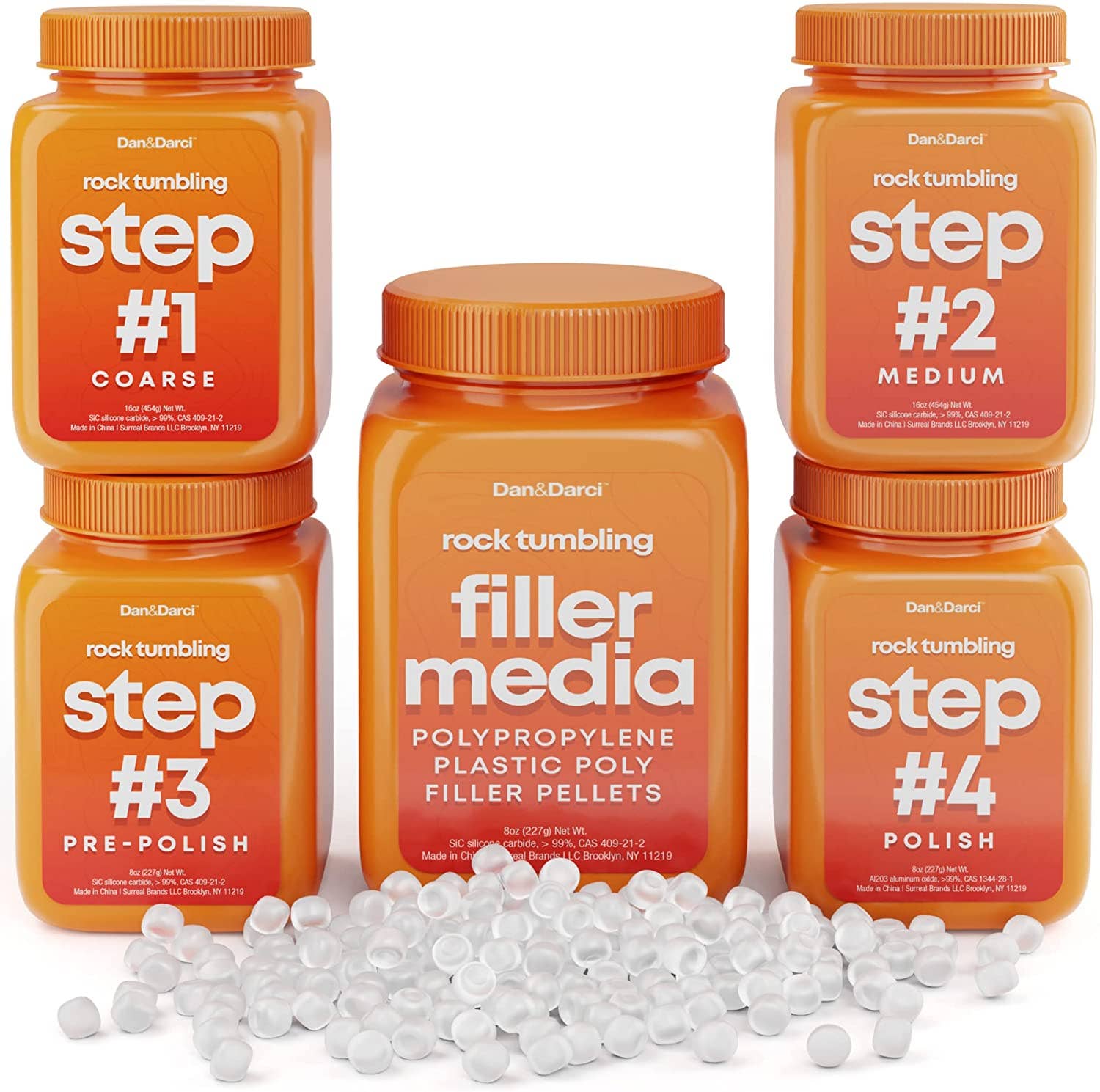 Image of five orange Grit Refill bottles from Dan&Darci, labeled from left to right: #1 Coarse, #3 Pre-Polish, Filler Media, #4 Polish, and #2 Medium. All bottles feature twist-off lids and are designed for rock tumbling. White plastic filler pellets are scattered in front, prepared for gem creation.