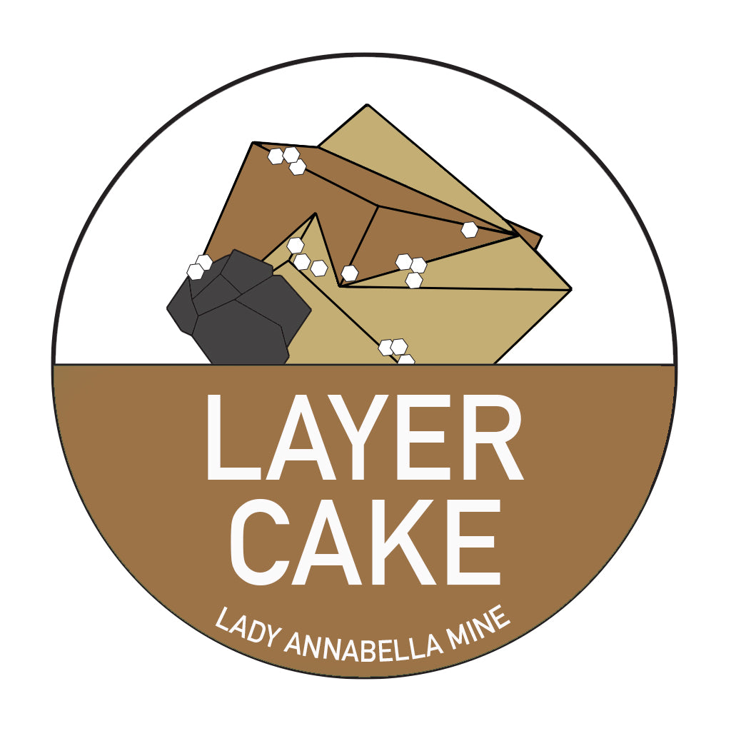 The logo for "Layer Cake" at Lady Annabella Mine by The Crystalary features stacked geometric shapes resembling cake layers, adorned with small white dots. Enclosed in a circle with a brown base, the full-color design includes the text "LAYER CAKE" in large white letters and "LADY ANNABELLA MINE" below, making it perfect for Lady Annabella Passport Stickers.