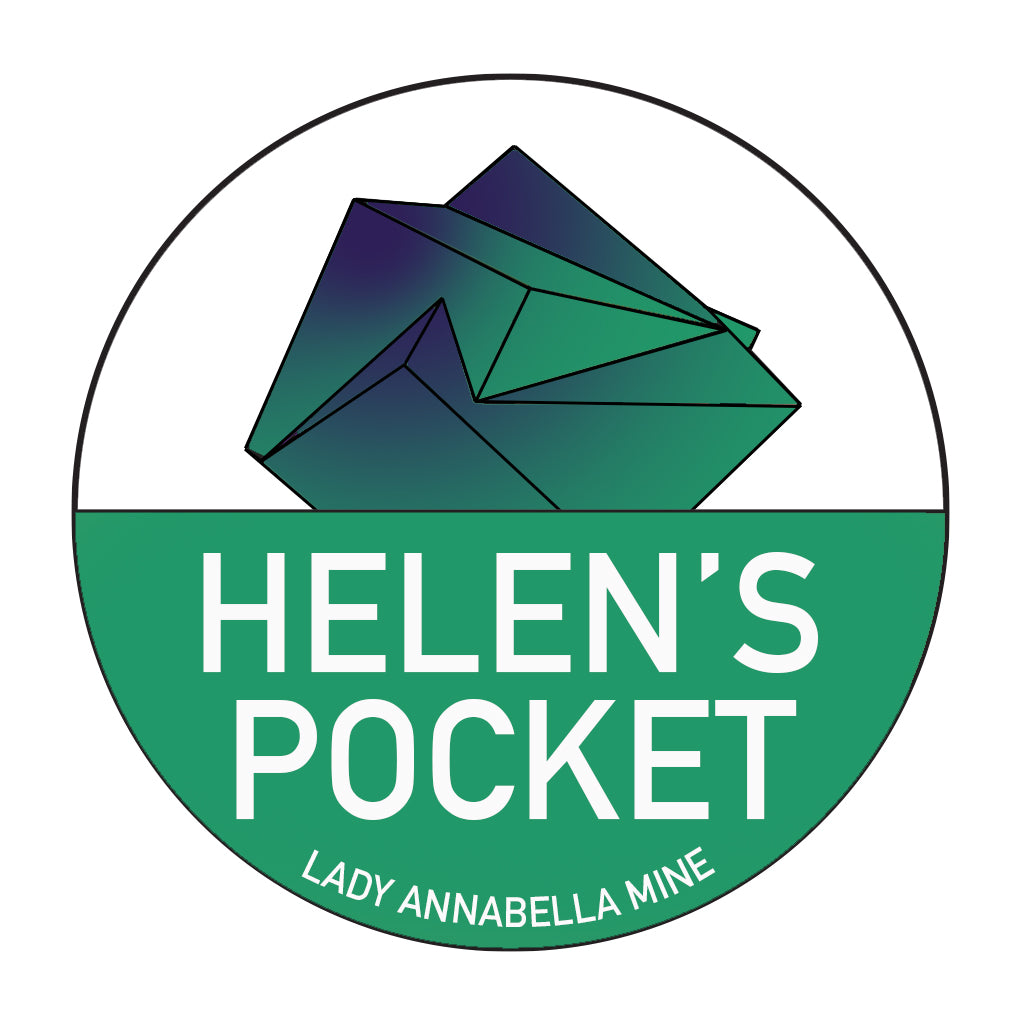 A circular logo showcases a geometric, crystal-like design in vibrant shades of green and blue at the top. Beneath it, "HELEN'S POCKET" is prominently displayed in bold white letters on a green background. Below this, the inscription "LADY ANNABELLA MINE" appears in smaller text, resembling an elegant sticker from The Crystalary's Lady Annabella Passport Stickers collection.