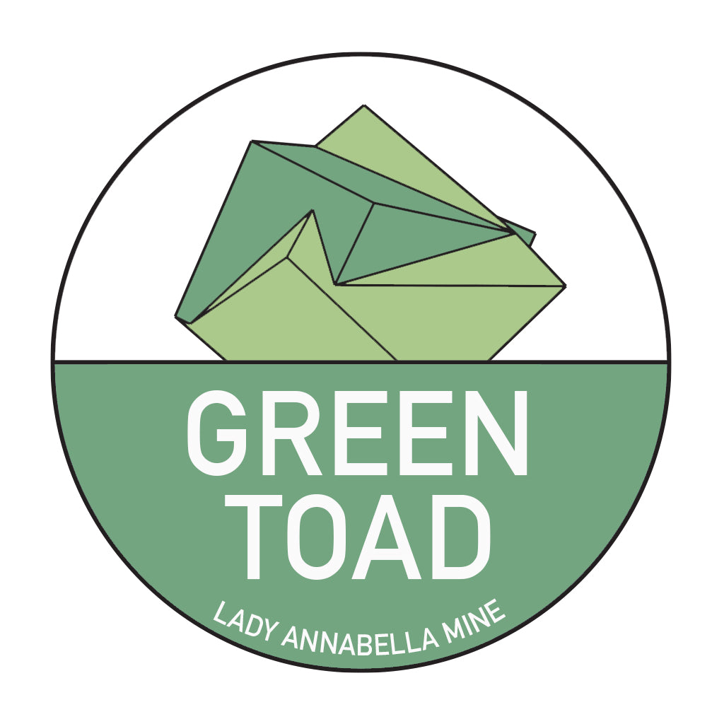 The Lady Annabella Passport Stickers by The Crystalary feature a circular logo with a green geometric origami toad above the words "GREEN TOAD" in white text. Below, "LADY ANNABELLA MINE" and "Fluorite Passport" are written in smaller white text. The background is split, with the upper half in white and the lower half in green, making them ideal for full-color stickers.